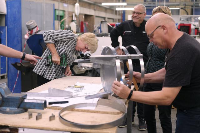 Foto af mennesker der arbejder i et værksted