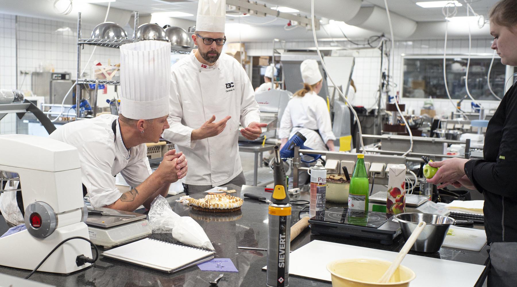Foto af kokke der arbejder i et køkken